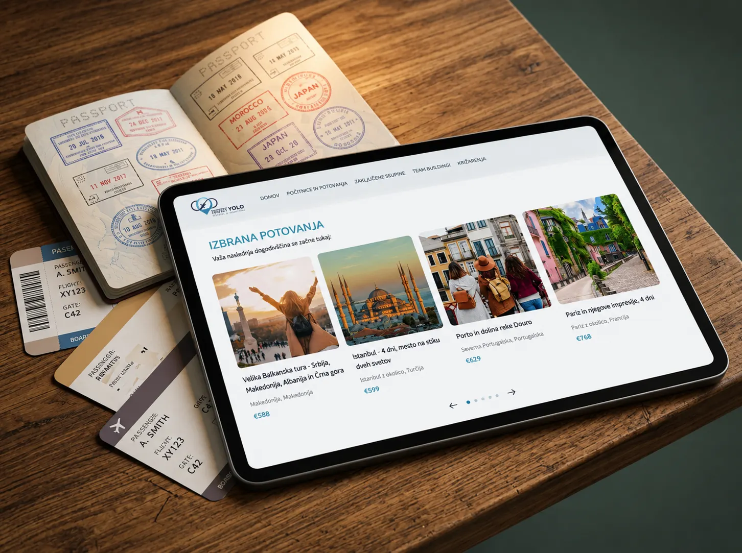 A branded travel-agency site on a tablet showing featured trips with prices, beside stamped passports and boarding passes